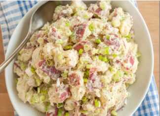 Ενα μπολ με πλούσια, κρεμώδη πατατοσαλάτα, γαρνιρισμένη με φρέσκα μυρωδικά, έτοιμη για σερβίρισμα.