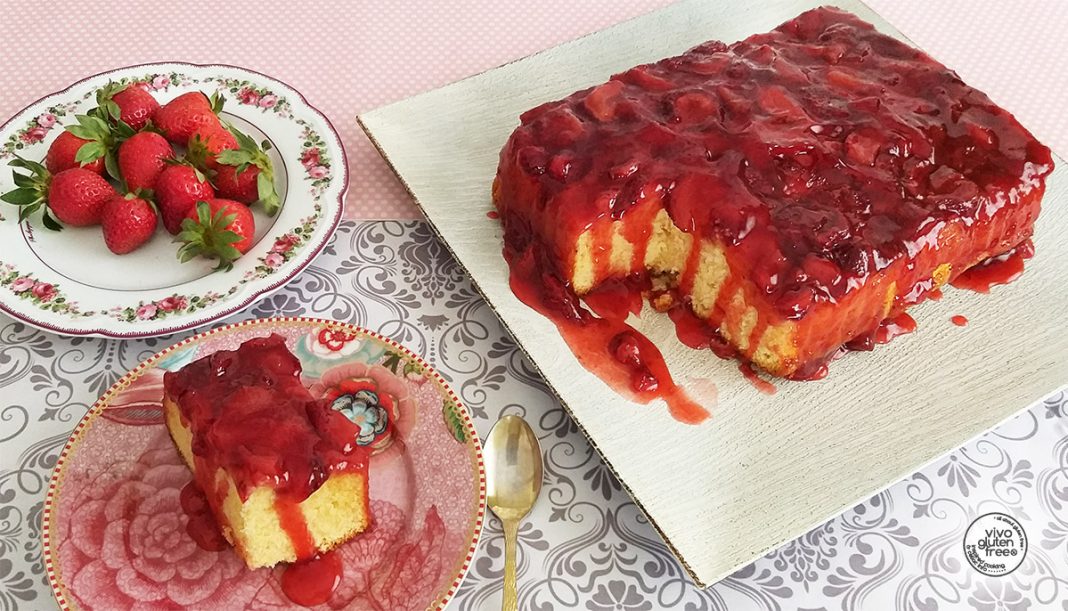 Ένα ανάποδο κέικ φράουλας με κόκκινες φράουλες να ξεχειλίζουν στην επιφάνεια.