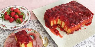 Ένα ανάποδο κέικ φράουλας με κόκκινες φράουλες να ξεχειλίζουν στην επιφάνεια.