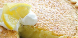 Ενα πυρεξ από κίτρινη λεμονόπιτα με μια στρώση λευκής σαντιγί στην κορυφή, τοποθετημένη σε ένα λευκό πιάτο.