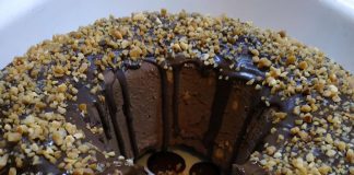 Κέικ μωσαϊκό, με ορατά κομμάτια μπισκότων και σοκολατένια κρέμα, γαρνιρισμένο με τριμμένο φουντούκι.