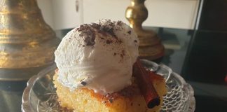 Ένα κομμάτι πορτοκαλόπιτας σε ένα πιάτο, με εμφανή τα τσαλακωμένα φύλλα και το σιρόπι.