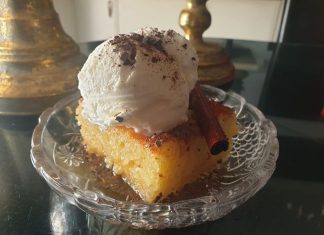 Ένα κομμάτι πορτοκαλόπιτας σε ένα πιάτο, με εμφανή τα τσαλακωμένα φύλλα και το σιρόπι.