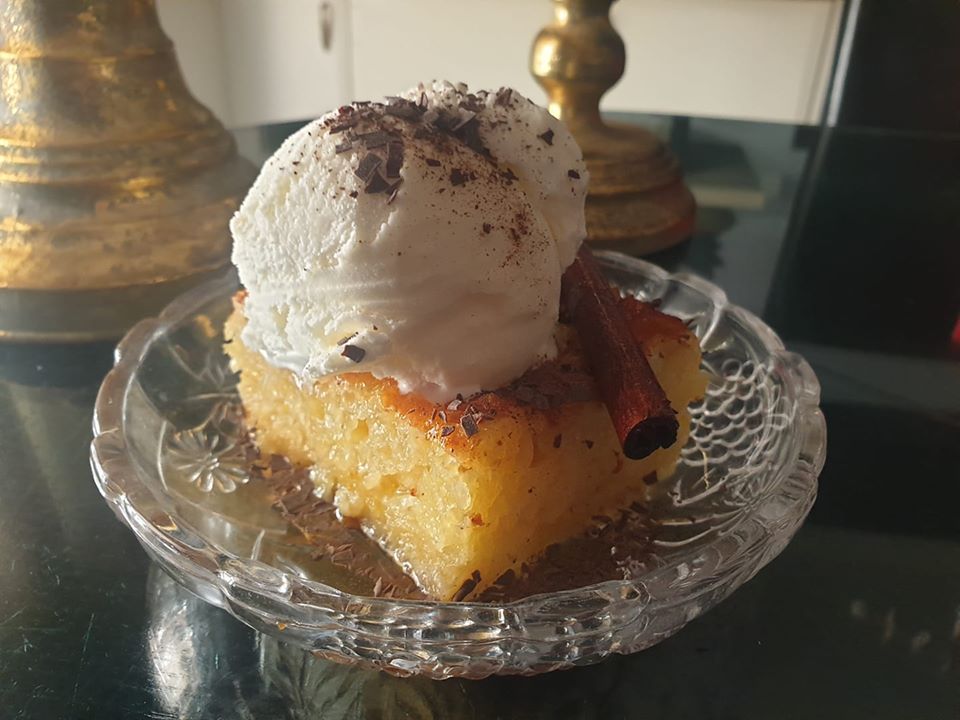 Πορτοκαλοπιτα με παγωτο Ένα κομμάτι πορτοκαλόπιτας σε ένα πιάτο, με εμφανή τα τσαλακωμένα φύλλα και το σιρόπι.