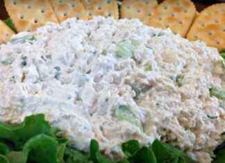 Μια πλούσια κοτοσαλάτα με κομμάτια στήθους κοτόπουλου και ψιλοκομμένα λαχανικά σε πιατέλα με φύλλα μαρουλιού