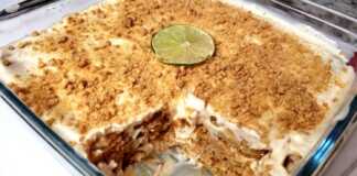 Ένα δροσερό γλυκό ταψιού με στρώσεις μπισκότων και λευκή κρέμα λάιμ πασπαλισμένο με τρίμμα μπισκότου και ξύσμα λάιμ