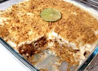 Ένα δροσερό γλυκό ταψιού με στρώσεις μπισκότων και λευκή κρέμα λάιμ πασπαλισμένο με τρίμμα μπισκότου και ξύσμα λάιμ