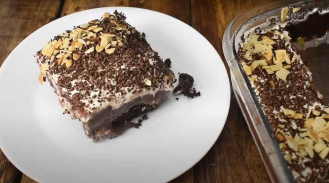 Γλυκό ψυγείου με βάση Oreo, λευκή κρέμα τυριού και σοκολατένια στρώση διακοσμημένο με τριμμένη σοκολάτα και αμύγδαλα