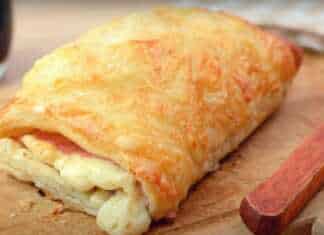 Τραγανή ζαμπονοτυρόπιτα από φύλλο σφολιάτας σε σχήμα μεγάλου κρουασάν με λιωμένη μοτσαρέλα στην κορυφή