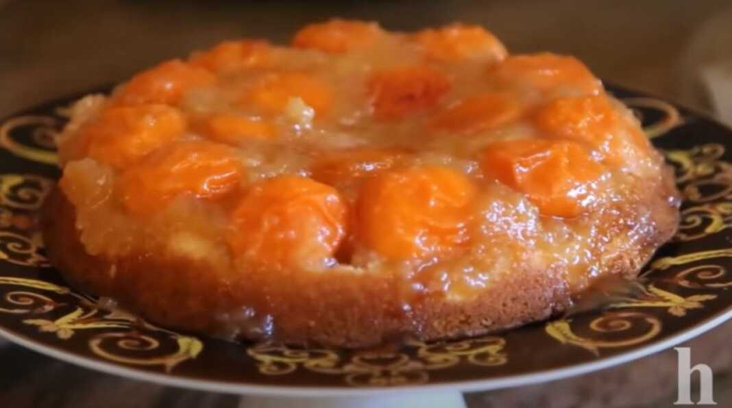 Λαχταριστό ανάποδο κέικ βερίκοκου σερβιρισμένο σε πιατέλα, με τα βερίκοκα στην κορυφή και πασπαλισμένο με ζάχαρη άχνη.