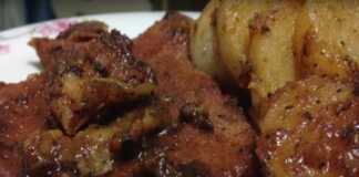 Πιάτο με μελωμένες χοιρινές μπριζόλες στο τηγάνι με πατάτες και πλούσια σάλτσα.