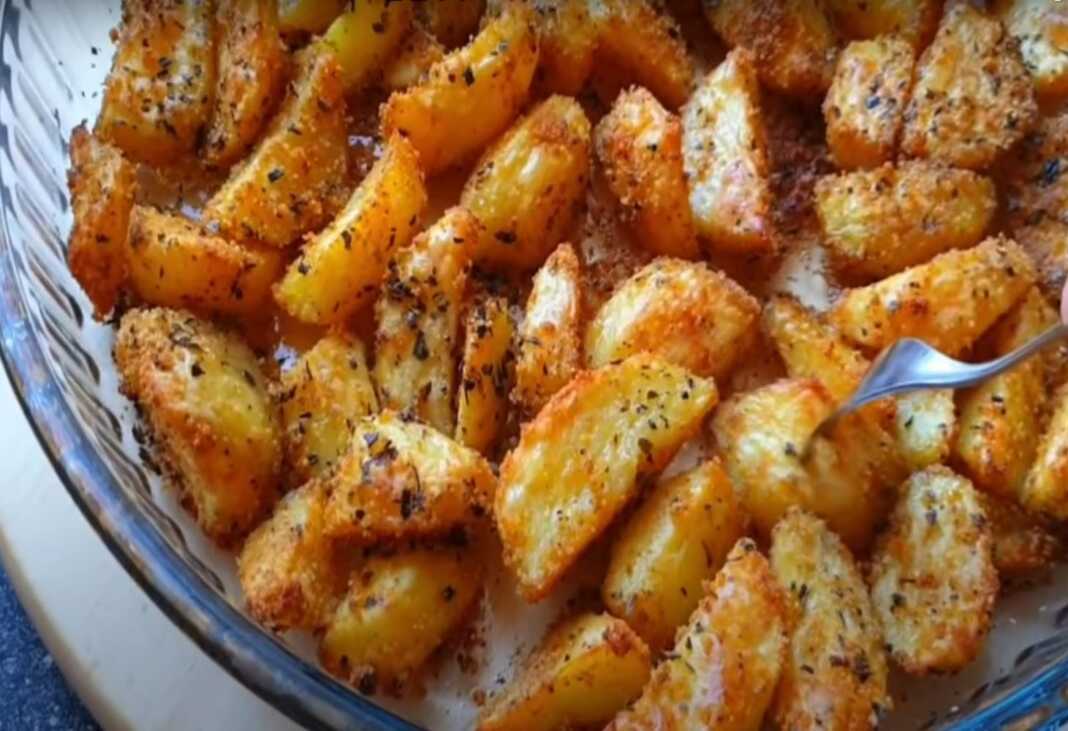 Χρυσαφένιες, τραγανές πατάτες φούρνου με πικάντικα μπαχαρικά και θυμάρι, σερβιρισμένες σε πιάτο.