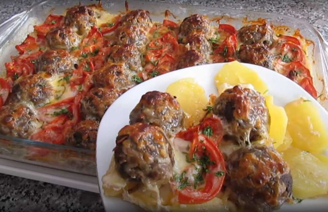 Ένα ταψί γεμάτο με ροδισμένα μπιφτέκια και φέτες πατάτας, με λιωμένο τυρί από πάνω, φρεσκοψημένο από το φούρνο