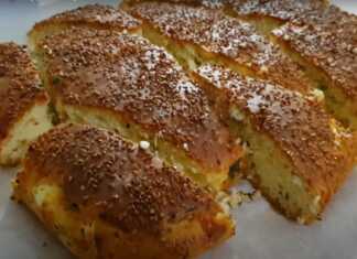 Αφράτο τυρόψωμο με σουσάμι σε ταψί, φρεσκοψημένο και χρυσαφένιο.