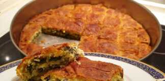 Μια λαχταριστή, χρυσαφένια χορτοτυρόπιτα, κομμένη σε κομμάτια, έτοιμη για σερβίρισμα.