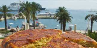 Μια χρυσαφένια, στρογγυλή κολοκυθόπιτα μέσα σε ένα αντικολλητικό τηγάνι, με την επιφάνειά της ελαφρώς ροδισμένη και τραγανή.