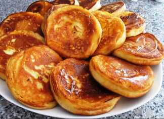 Ψηλές και αφράτες χρυσαφένιες τηγανίτες στοιβαγμένες η μία πάνω στην άλλη και περιχυμένες με ρευστό μέλι