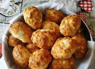 Χρυσαφένια και αφράτα τυροψωμάκια με φέτα τοποθετημένα σε ταψί με αντικολλητικό χαρτί μόλις βγήκαν από τον φούρνο