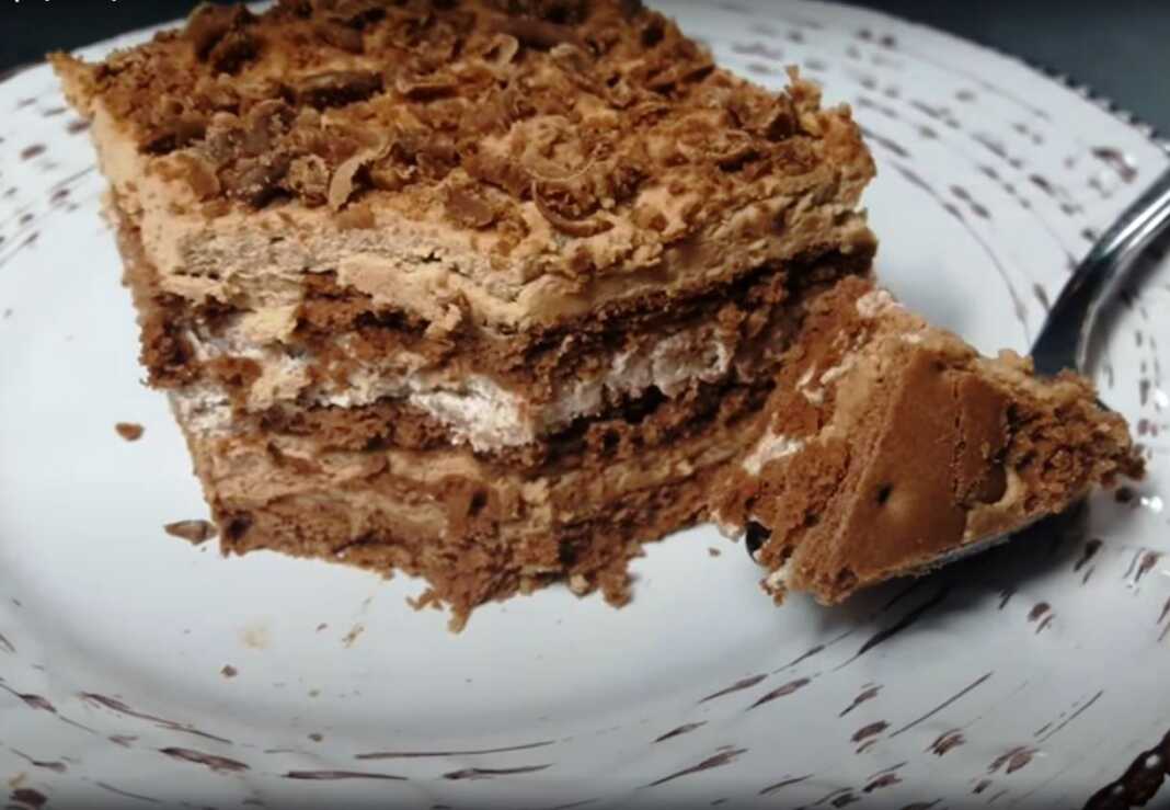 Μια φωτογραφία από ένα κομμένο γλυκό ψυγείου με 3 υλικά, που αποκαλύπτει τις στρώσεις μπισκότων, λευκής και σοκολατένιας κρέμας.