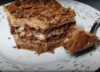 Μια φωτογραφία από ένα κομμένο γλυκό ψυγείου με 3 υλικά, που αποκαλύπτει τις στρώσεις μπισκότων, λευκής και σοκολατένιας κρέμας.