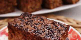 Ένα κομμάτι μηλοκαρυδόπιτας με σκούρο γλάσο σοκολάτας και τρούφα σε ένα άσπρο πιάτο.