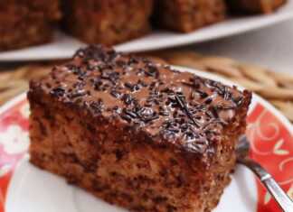 Ένα κομμάτι μηλοκαρυδόπιτας με σκούρο γλάσο σοκολάτας και τρούφα σε ένα άσπρο πιάτο.