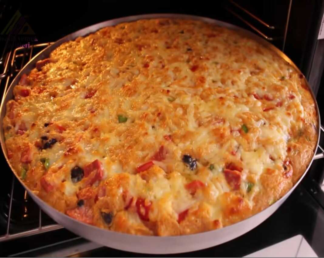 Μία ολόκληρη Πίτα του Καλοκαιριού, φρεσκοψημένη, με χρυσαφένια επιφάνεια και λαχανικά ορατά.