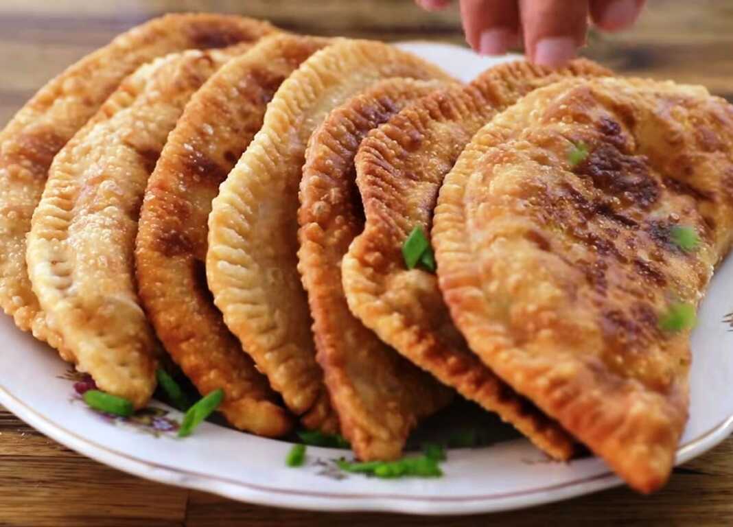 Χρυσαφένιες τηγανητές κιμαδόπιτες σε σχήμα μισοφέγγαρου πάνω σε χαρτί κουζίνας έτοιμες για σερβίρισμα