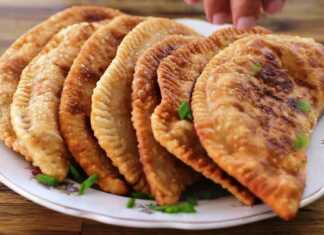 Χρυσαφένιες τηγανητές κιμαδόπιτες σε σχήμα μισοφέγγαρου πάνω σε χαρτί κουζίνας έτοιμες για σερβίρισμα