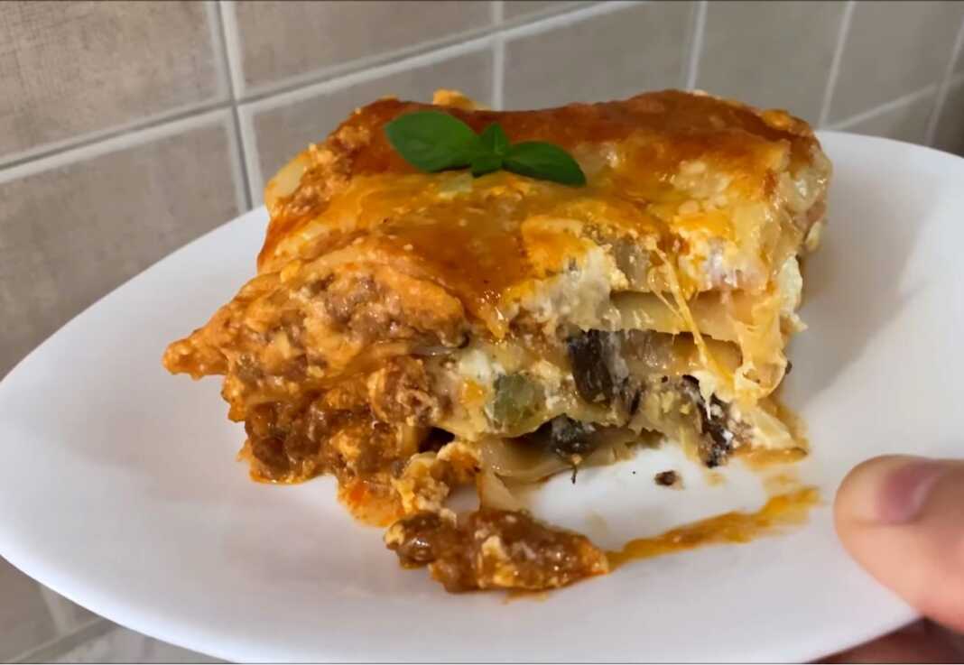 Ένα ταψί με λαχταριστά λαζάνια που έχουν ροδίσει στην επιφάνεια με λιωμένη μοτσαρέλα και στρώσεις από κιμά και λαχανικά