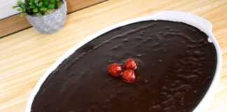 Ένα οβάλ πυρέξ που περιέχει ένα γλυκό σοκολάτας με τρεις στρώσεις: σκούρα σοκολάτα κάτω, λευκή σαντιγί στη μέση και γυαλιστερό γλάσο σοκολάτας στην κορυφή, διακοσμημένο με κόκκινα κερασάκια.