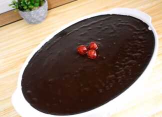 Ένα οβάλ πυρέξ που περιέχει ένα γλυκό σοκολάτας με τρεις στρώσεις: σκούρα σοκολάτα κάτω, λευκή σαντιγί στη μέση και γυαλιστερό γλάσο σοκολάτας στην κορυφή, διακοσμημένο με κόκκινα κερασάκια.