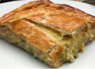 Κομμάτι με ροδοκοκκινισμένη πρασόπιτα πασπαλισμένη με σουσάμι