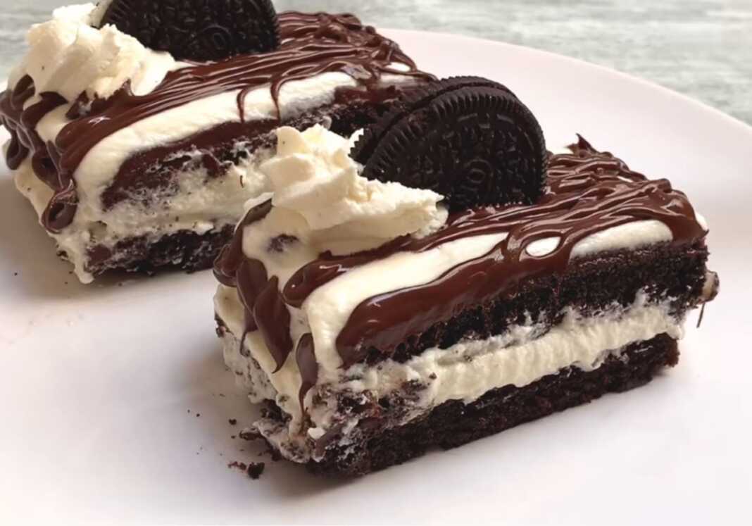 Λαχταριστό γλυκό με στρώσεις κέικ Oreo και λευκή κρέμα γάλακτος γαρνιρισμένο με λιωμένη σοκολάτα