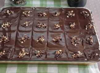 Κομμάτι σοκολατένιου κέικ με στρώση λευκής κρέμας και πλούσιο γλάσο σοκολάτας σερβιρισμένο σε πιάτο