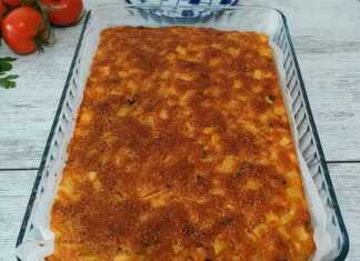 Μια μεγάλη, χρυσαφένια πίτα με φέτα και πατάτες, κομμένη σε τετράγωνα κομμάτια, έτοιμη για σερβίρισμα.