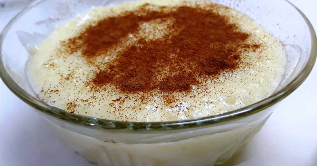 Μπολ με κρεμώδες ρυζόγαλο βανίλια, πασπαλισμένο με κανέλα, έτοιμο για σερβίρισμα.