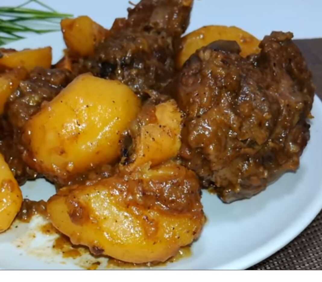 αρνάκι στην κατσαρόλα5 Ένα πιάτο με κομμάτια αρνιού και πατάτες σε πλούσια καφέ σάλτσα, έτοιμο για σερβίρισμα.