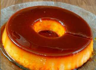 Μια λαχταριστή πουτίγκα ψωμιού με χρυσή καραμέλα να ρέει στις πλευρές της αναποδογυρισμένη σε πιατέλα