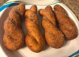 Ένα πιάτο γεμάτο αφράτα κουλουράκια κανέλας, επικαλυμμένα με ζάχαρη και κανέλα, έτοιμα για σερβίρισμα