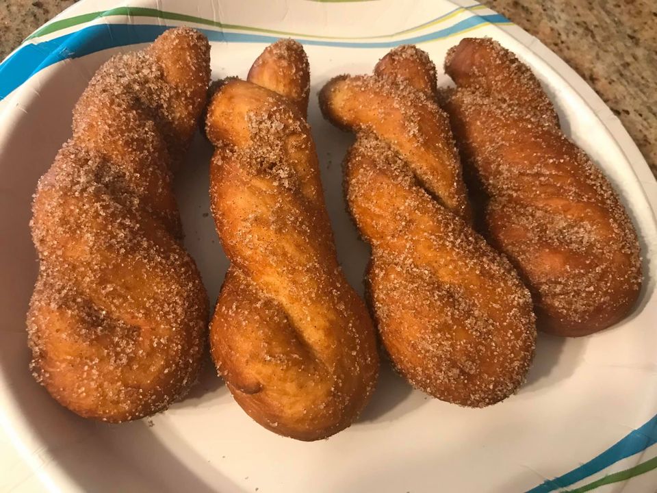 κουλουρακια κανέλας0 Ένα πιάτο γεμάτο αφράτα κουλουράκια κανέλας, επικαλυμμένα με ζάχαρη και κανέλα, έτοιμα για σερβίρισμα