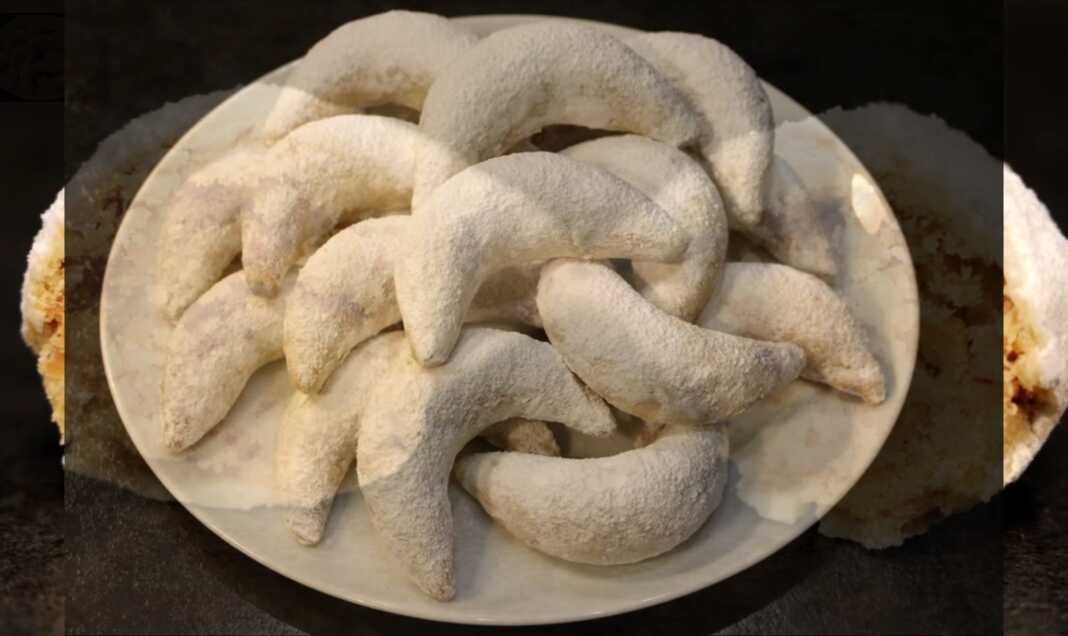 Μικρά καμπυλωτά γλυκάκια σε σχήμα μισοφέγγαρου πασπαλισμένα με λευκή ζάχαρη άχνη και αρωματισμένα με ανθόνερο