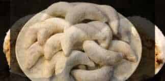 Μικρά καμπυλωτά γλυκάκια σε σχήμα μισοφέγγαρου πασπαλισμένα με λευκή ζάχαρη άχνη και αρωματισμένα με ανθόνερο