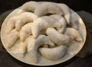 Μικρά καμπυλωτά γλυκάκια σε σχήμα μισοφέγγαρου πασπαλισμένα με λευκή ζάχαρη άχνη και αρωματισμένα με ανθόνερο