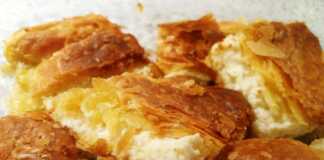 Βελούδινη κρεμένια τυρόπιτα κομμένη σε κομμάτια, με χρυσαφένια, αφράτη σφολιάτα.