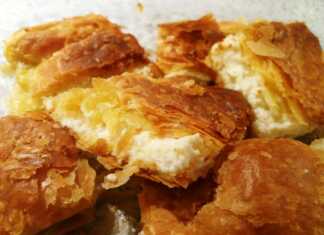 Βελούδινη κρεμένια τυρόπιτα κομμένη σε κομμάτια, με χρυσαφένια, αφράτη σφολιάτα.