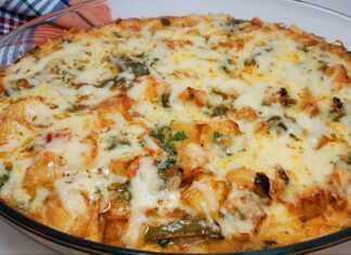 Ένα ταψάκι με ροδοκοκκινισμένη ομελέτα φούρνου με πατάτες, πιπεριές και λιωμένο τυρί, πασπαλισμένη με φρέσκο μαϊντανό.