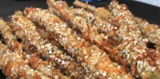 Τραγανά κριτσίνια μελιτζάνας παναρισμένα με σουσάμι και τυρί, σερβιρισμένα με σάλτσα γιαουρτιού.