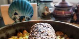 Ρολό κιμά με βραστά αυγά στο κέντρο, κομμένο σε φέτες, σερβιρισμένο με πατάτες φούρνου.