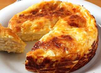 Πολύστρωτη πίτα φτιαγμένη με τορτίγιες και ενδιάμεσες στρώσεις από κρεμώδη γέμιση τυριών. Η επιφάνεια είναι χρυσαφένια και ψημένη στο γκριλ.